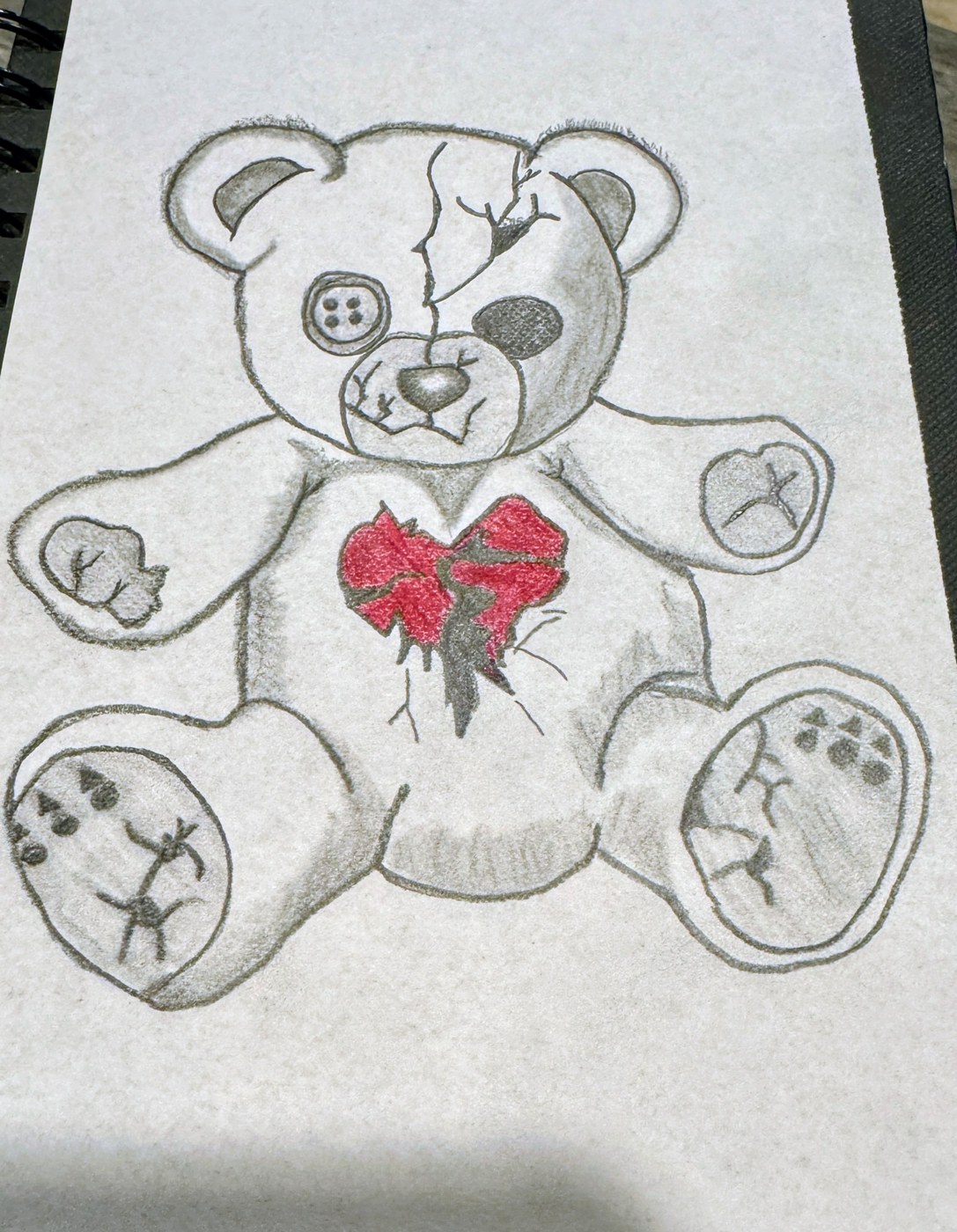 A worn teddy bear stitched and cracked, holding a red heart