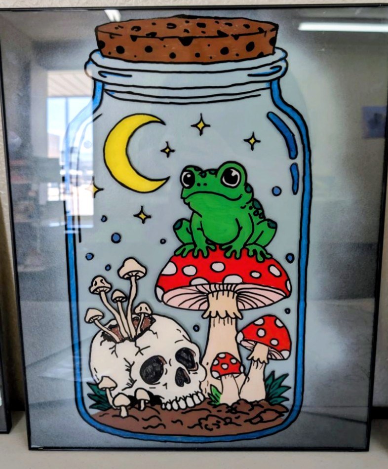 A frog on a toadstool inside a corked jar with a moon, stars and a small skull