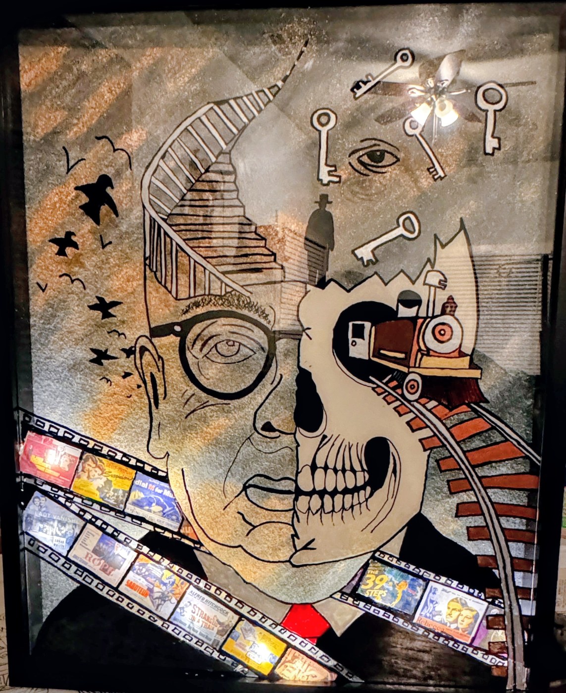 A Hitchcock homage: half face, half skull, with birds, a staircase, keys and a filmstrip